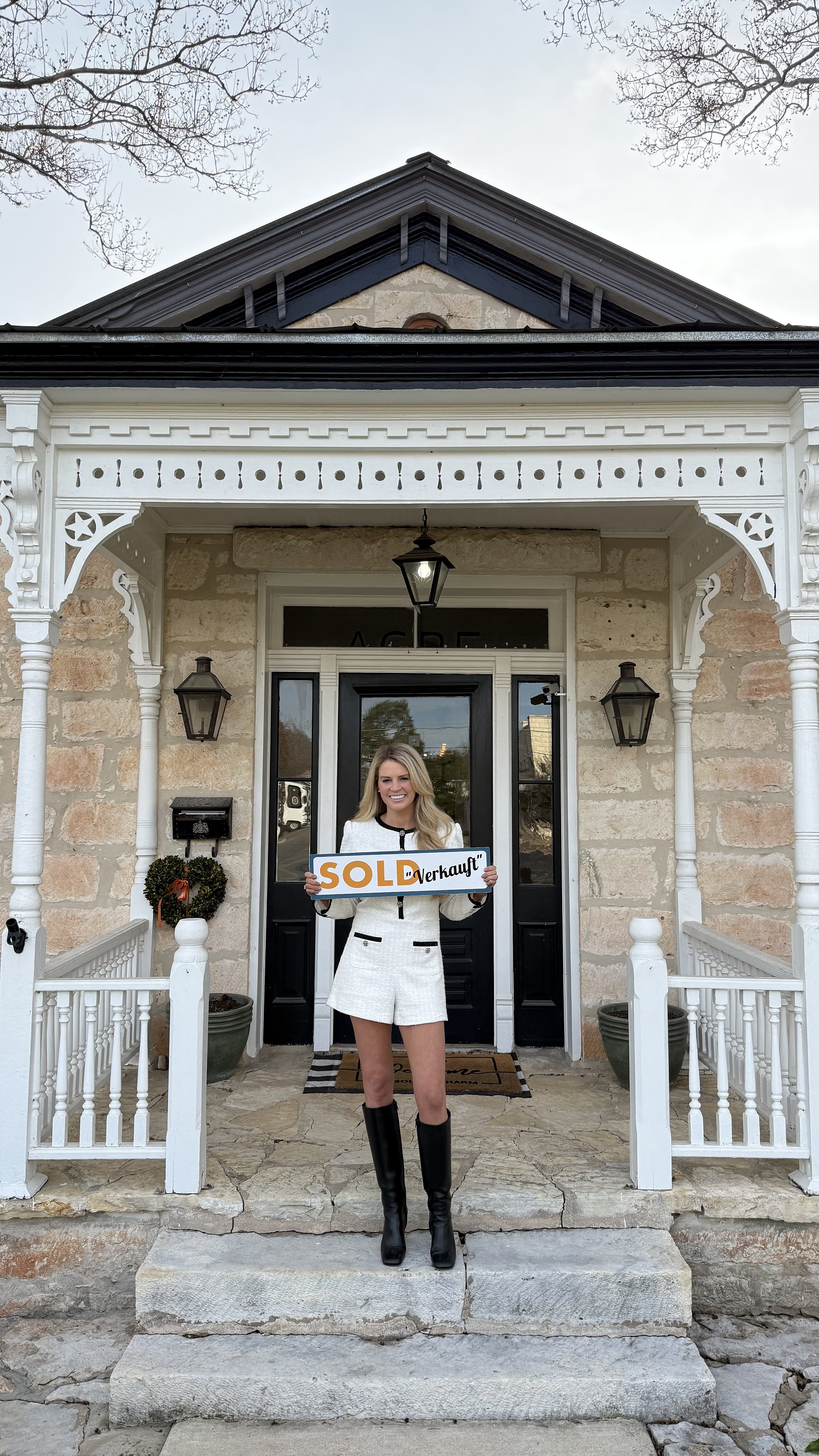 Savannah Sikes with a SOLD sign on a historic Fredericksburg porch