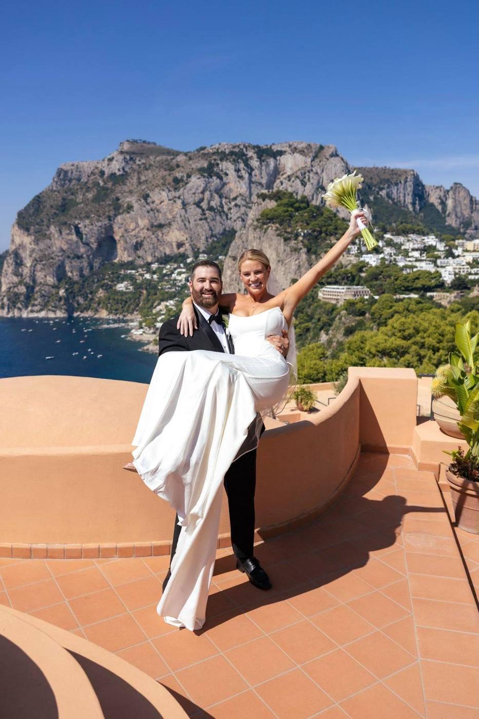 David lifting Savannah on their wedding day in Capri