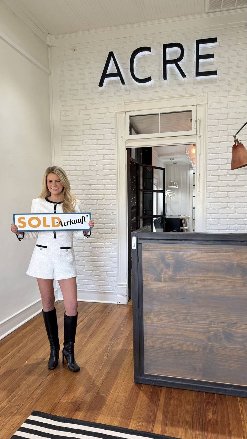 Savannah Sikes with a SOLD sign in the Absolute Charm office