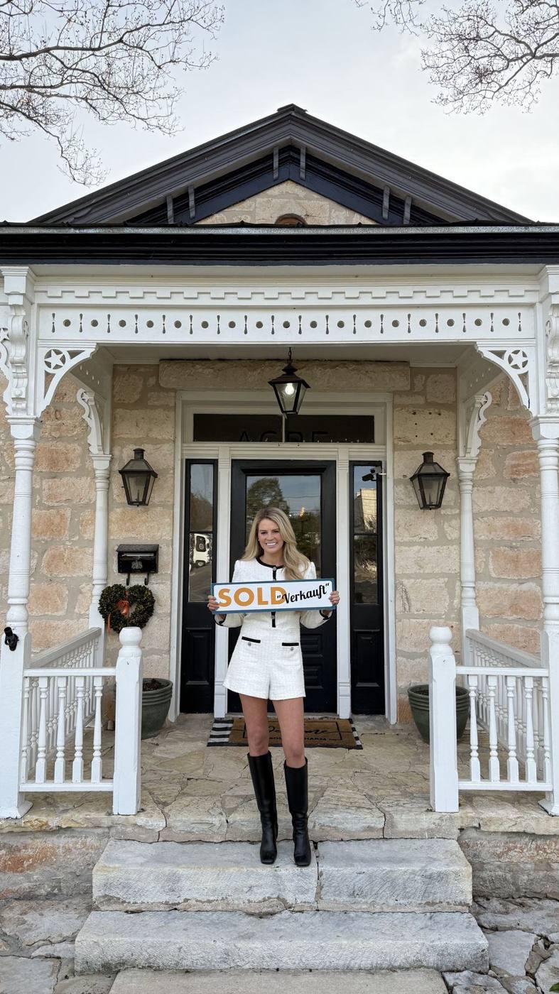 Savannah Sikes with a SOLD sign on a historic Fredericksburg porch