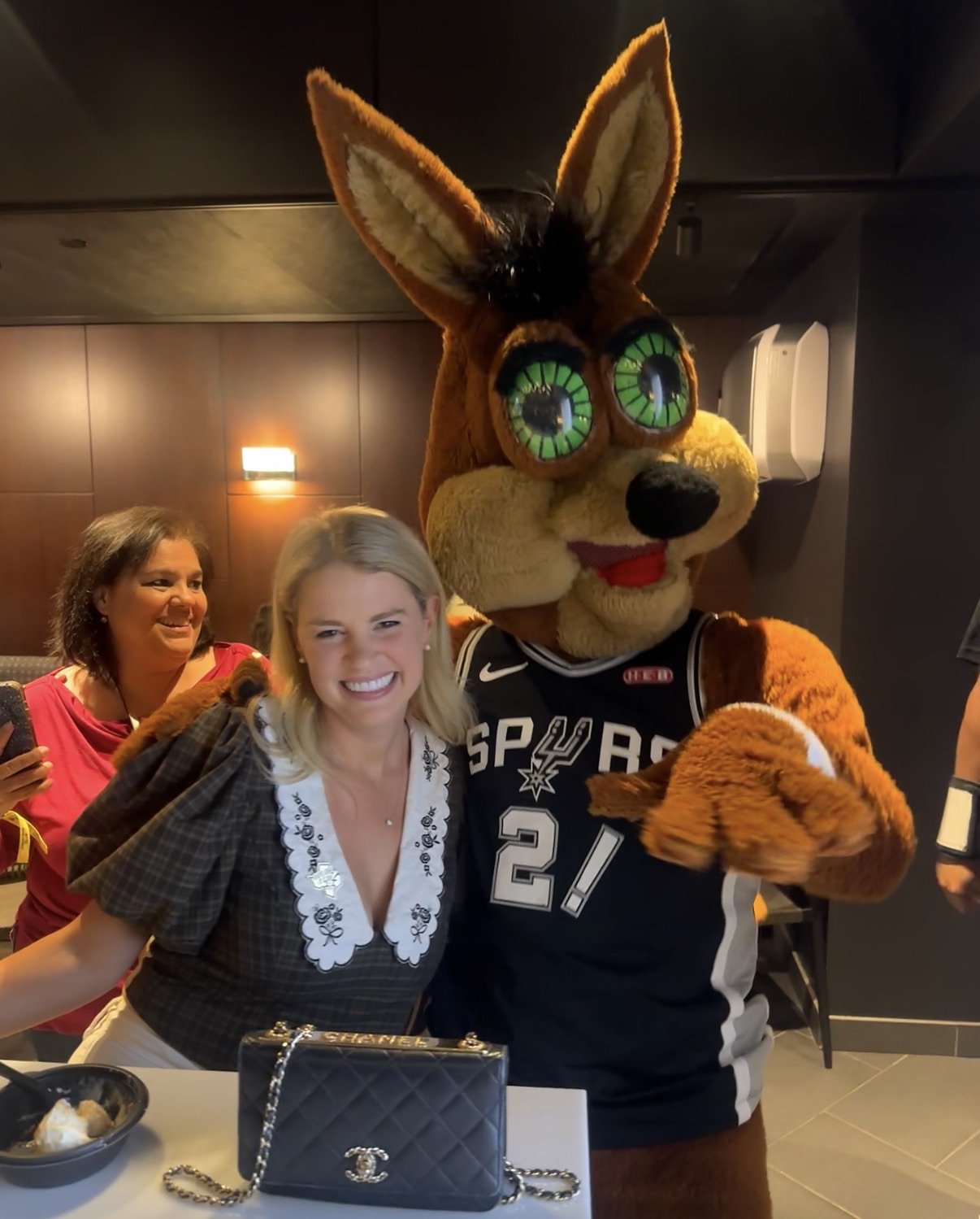 Savannah Sikes with the Spurs Coyote in the courtside club